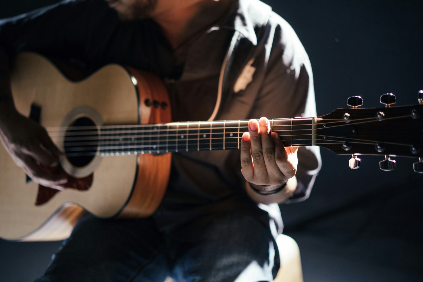 An acoustic guitar in warm studio light — the writer's workshop.